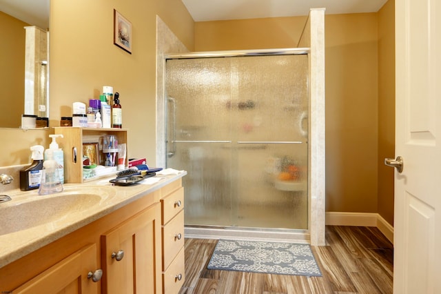 bathroom with hardwood / wood-style flooring, vanity, and an enclosed shower