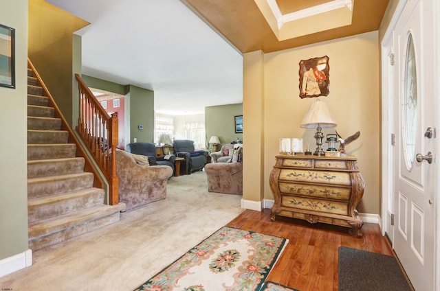 foyer entrance with ornamental molding and hardwood / wood-style flooring