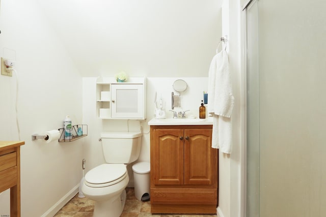 bathroom with vanity, toilet, and a shower with door