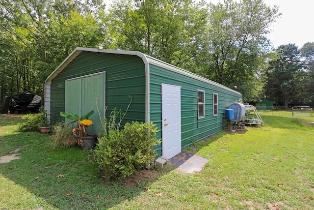 view of outbuilding with a yard