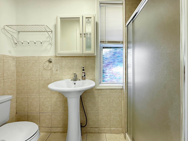 bathroom with walk in shower, tile walls, toilet, and tile patterned floors