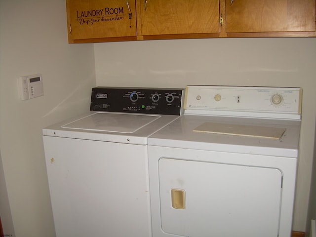 washroom featuring cabinets and washing machine and dryer