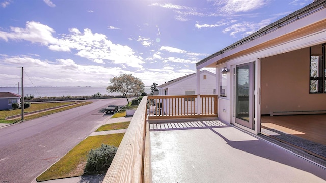 exterior space with a water view and baseboard heating