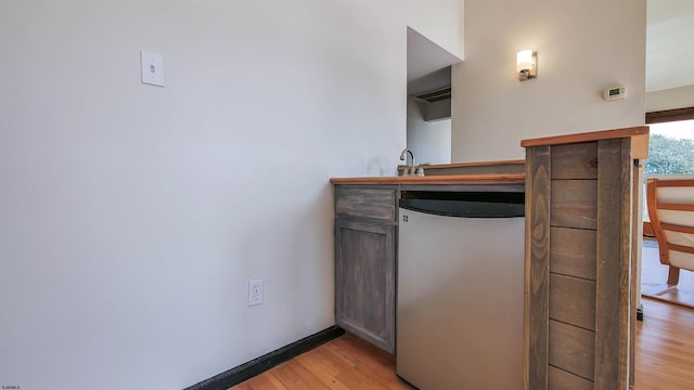 kitchen with stainless steel fridge and light hardwood / wood-style floors