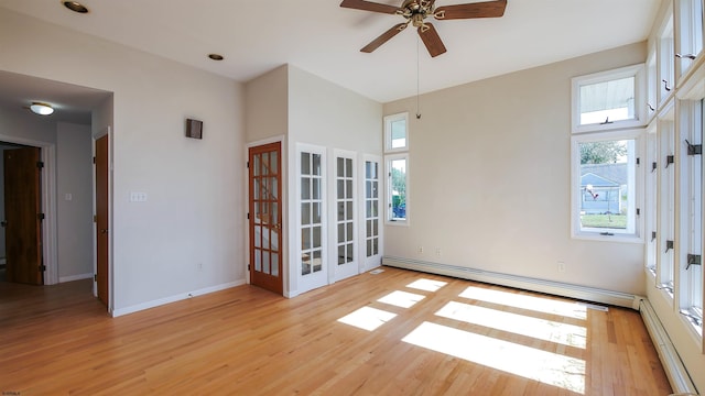 spare room featuring french doors, light hardwood / wood-style flooring, a baseboard heating unit, and ceiling fan