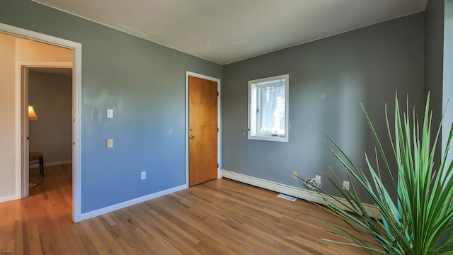 unfurnished bedroom featuring light hardwood / wood-style flooring and a baseboard radiator