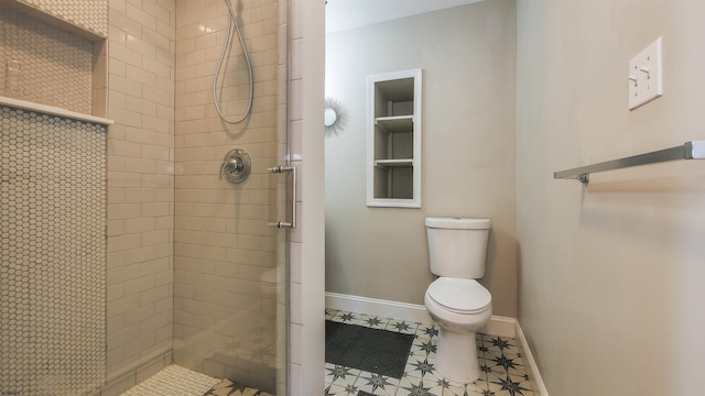 bathroom featuring a tile shower and toilet