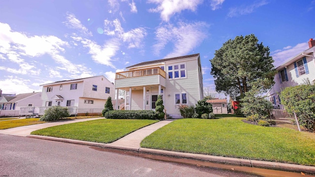 view of front of property with a balcony and a front lawn