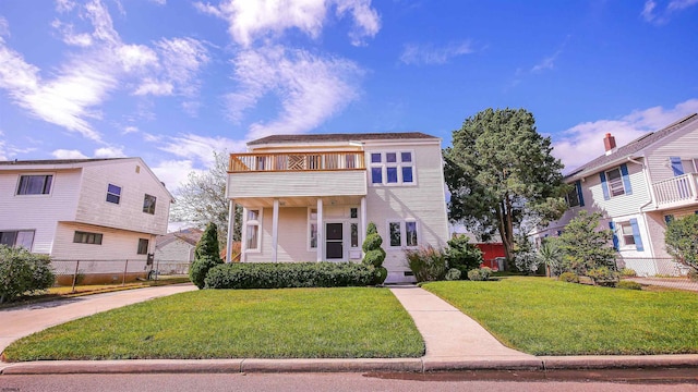 view of front facade with a balcony and a front lawn