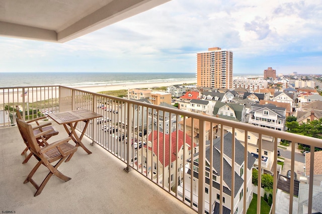 balcony with a water view and a view of the beach