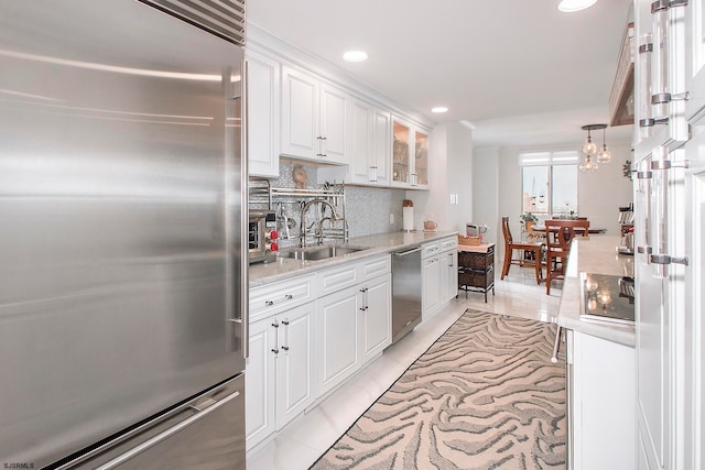 kitchen with tasteful backsplash, sink, white cabinetry, an inviting chandelier, and stainless steel appliances