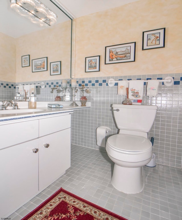 bathroom with tile walls, tile patterned flooring, vanity, and toilet