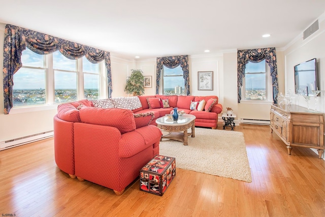 living room featuring a healthy amount of sunlight, baseboard heating, and light hardwood / wood-style flooring