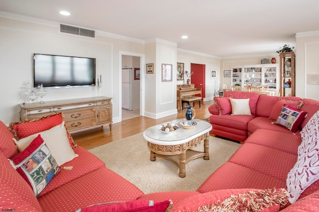 living room with crown molding and light hardwood / wood-style floors