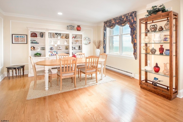 dining room with light hardwood / wood-style flooring, a baseboard heating unit, and crown molding