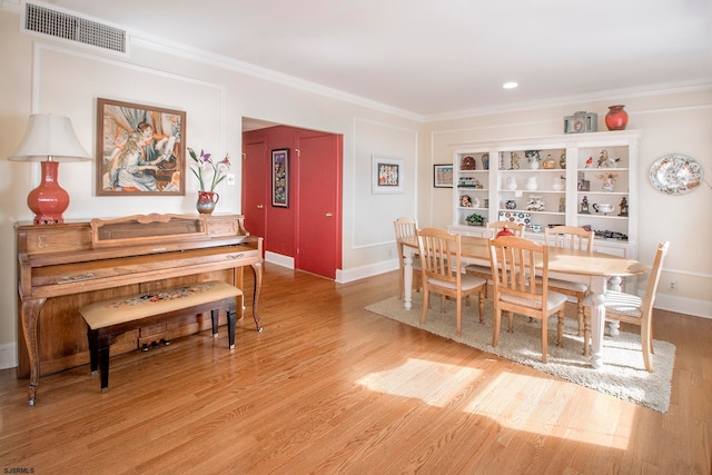 dining area featuring light hardwood / wood-style floors and crown molding