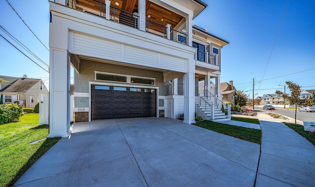 view of front of house with a balcony, a garage, and a front yard