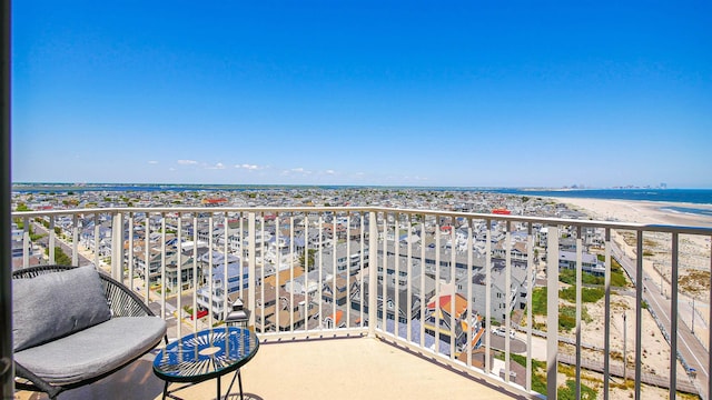 balcony featuring a water view and a beach view