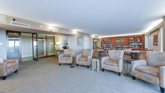 carpeted living room with a textured ceiling, french doors, visible vents, and baseboards