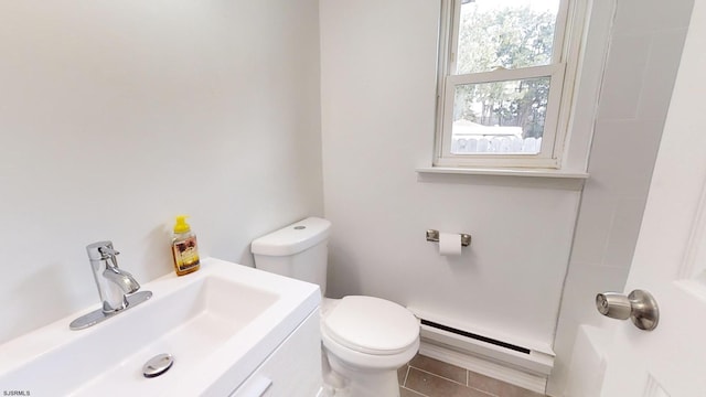 bathroom with a baseboard heating unit, tile patterned floors, vanity, and toilet