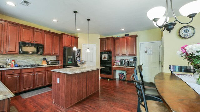 kitchen featuring backsplash, a kitchen island, black appliances, decorative light fixtures, and dark hardwood / wood-style floors