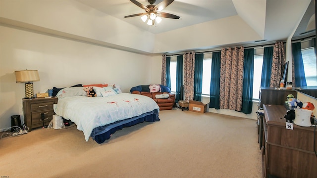 carpeted bedroom with ceiling fan and a tray ceiling