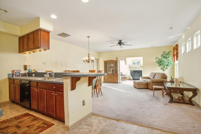 kitchen featuring light carpet, kitchen peninsula, a breakfast bar, sink, and decorative light fixtures