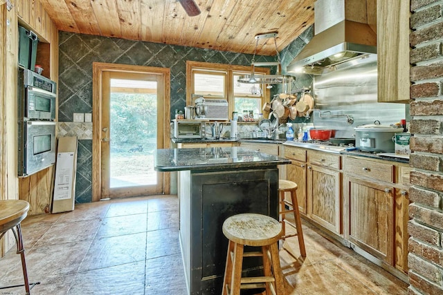 kitchen with a kitchen breakfast bar, wall chimney exhaust hood, a center island, and wooden ceiling