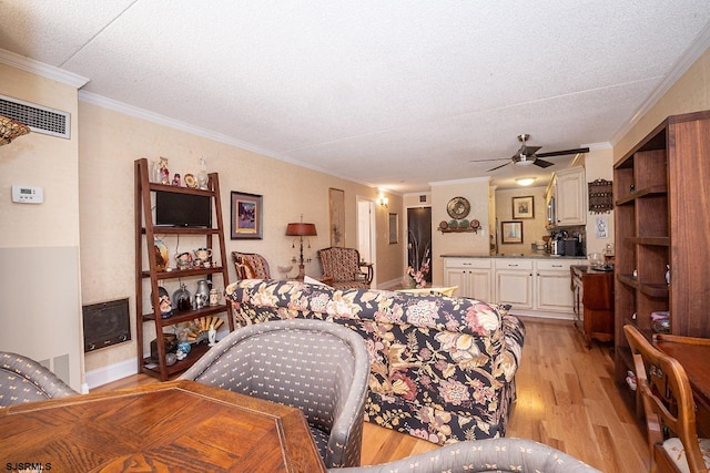 bedroom with a textured ceiling, crown molding, light hardwood / wood-style floors, and ceiling fan