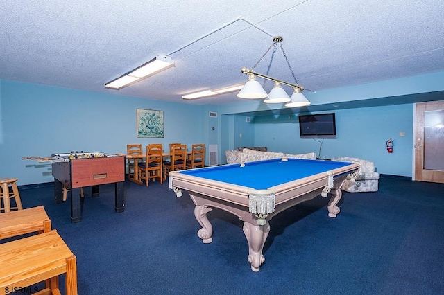 rec room with a textured ceiling, dark carpet, and billiards