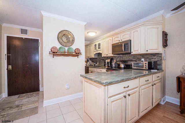 kitchen with sink, backsplash, stainless steel appliances, dark stone counters, and crown molding