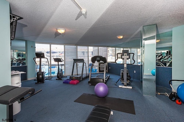 gym featuring floor to ceiling windows and a textured ceiling