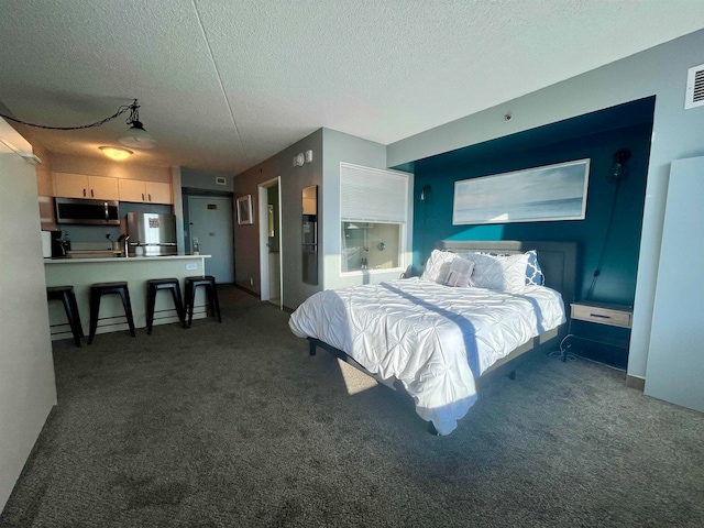 carpeted bedroom featuring a textured ceiling and stainless steel fridge