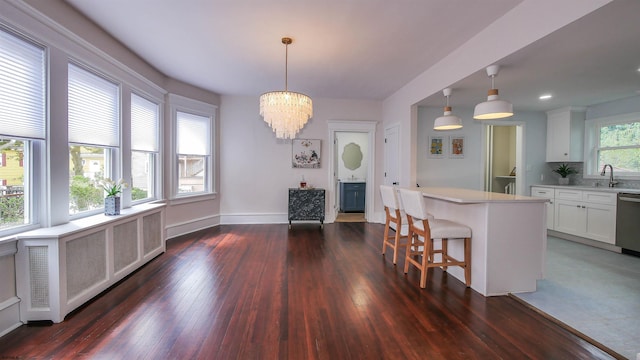 kitchen with pendant lighting, white cabinetry, dark hardwood / wood-style flooring, and a wealth of natural light