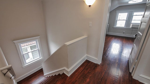 staircase featuring wood-type flooring, cooling unit, and vaulted ceiling