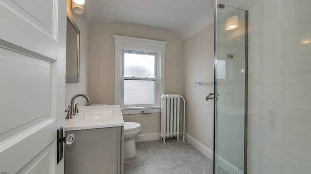 bathroom featuring radiator heating unit, vanity, tile patterned floors, an enclosed shower, and toilet