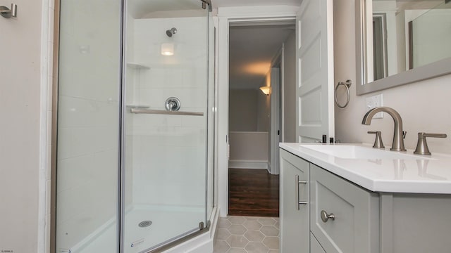 bathroom with tile patterned flooring, a shower with shower door, and vanity