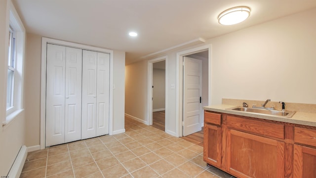 interior space featuring baseboard heating, sink, and light tile patterned floors