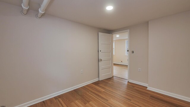 spare room with a baseboard radiator and light wood-type flooring