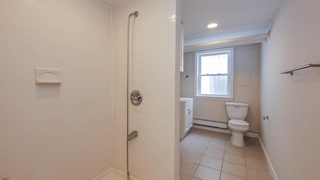 bathroom with vanity, a baseboard heating unit, tile patterned floors, tiled shower, and toilet