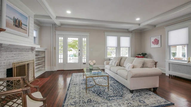 living room with coffered ceiling, a brick fireplace, beam ceiling, and dark wood-type flooring