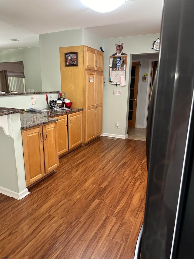 kitchen featuring dark stone counters and dark hardwood / wood-style floors