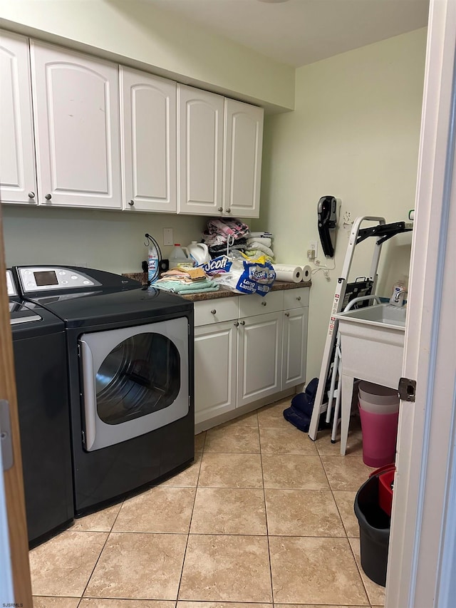 washroom with separate washer and dryer, cabinets, and light tile patterned flooring