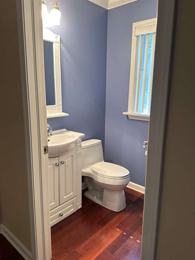 bathroom with ornamental molding, vanity, toilet, and hardwood / wood-style flooring