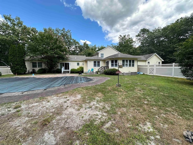 back of house with a lawn and a swimming pool side deck