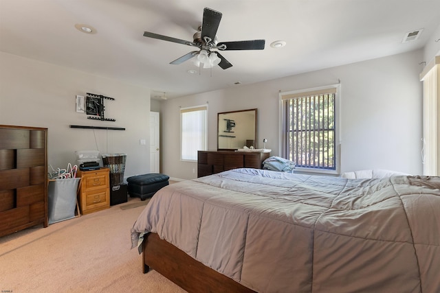 bedroom with multiple windows, ceiling fan, and carpet