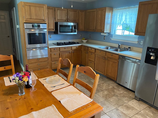 kitchen featuring light tile patterned flooring, appliances with stainless steel finishes, and sink