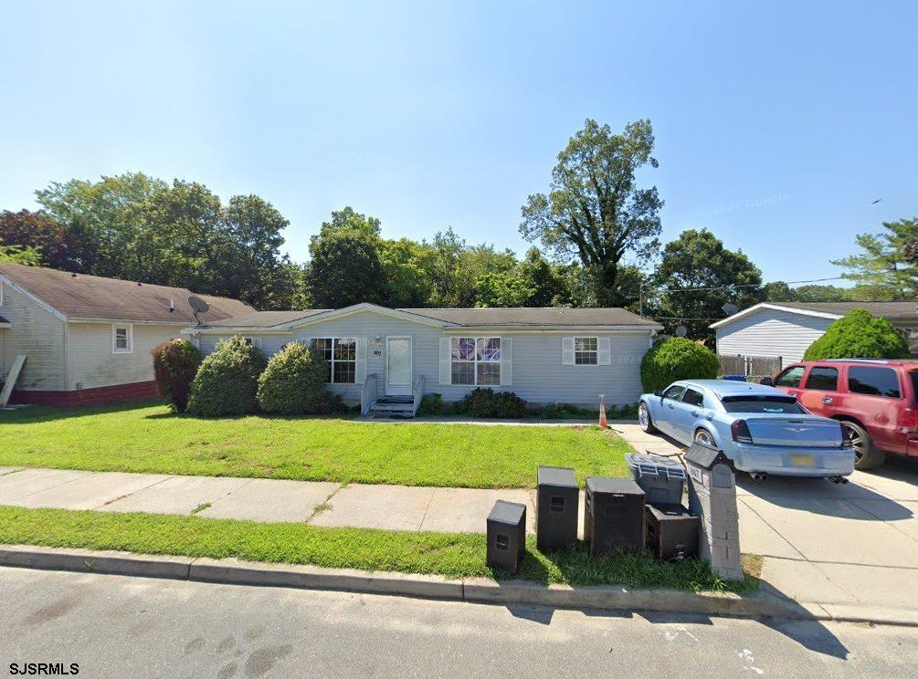 single story home featuring a front lawn