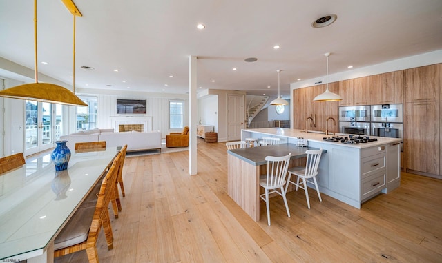 109 S 11th Ave, Longport, NJ 08403 - kitchen with a large island with sink, light wood-type flooring, open floor plan, decorative light fixtures, and double oven