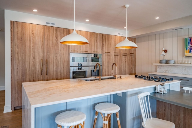 109 S 11th Ave, Longport, NJ 08403 - kitchen featuring modern cabinets, stainless steel double oven, brown cabinets, a sink, and a breakfast bar